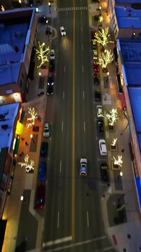 A top-down aerial shot captures traffic moving through La Grange, Illinois intersection at dusk, surrounded by illuminated storefronts and decorative lights.