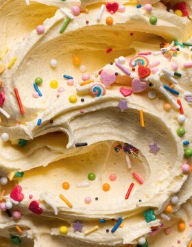 A swirly close-up of buttercream frosting with sprinkles