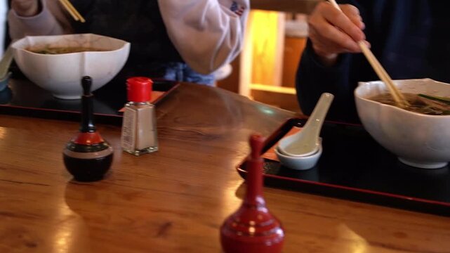 日本旅行で蕎麦を食べる外国人親子、日本の食文化を体験する家族連れ 観光・インバウンド・食事風景