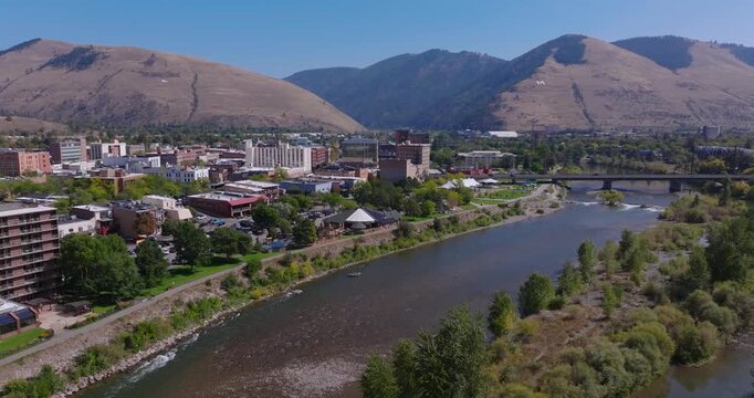 Wide aerial tracking left of Missoula Montana downtown along river