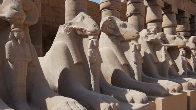 Karnak Temple in Luxor, Egypt. Stunning row of ram-headed sphinxes each holding a small pharaoh statue.