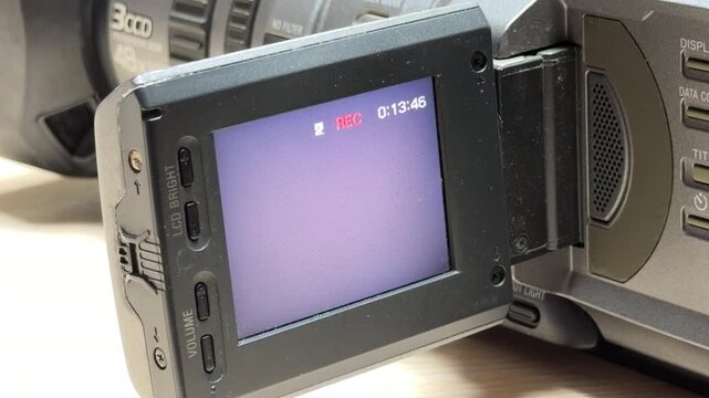 A classic 3CCD camcorder initiates a new recording, showing a red "REC" icon on the screen. This action triggers a short, high-pitched electronic beep to confirm the session has started.