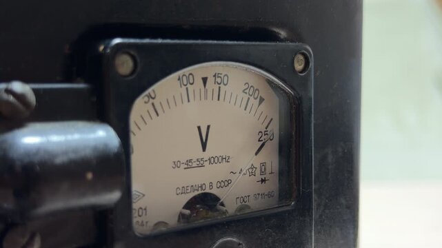 An analog voltmeter needle fluctuates as electricity flows through the internal coils. This electrical regulation produces a steady, low-frequency hum and a faint mechanical vibration.