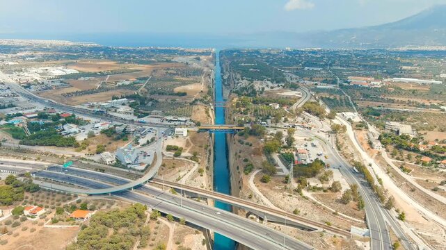 Corinth Canal, Greece. The Corinth Canal is a sluiceless shipping canal in Greece, connecting the Saronic Gulf of the Aegean and the Gulf of Corinth of the Ionian Sea. Drone footage, Departure of the