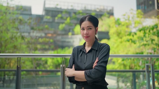 Confident Professional in the city: A composed professional woman, exudes confidence with crossed arms, against an urban backdrop, representing leadership and determination.