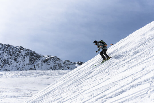 Skier riding down steep ski slope