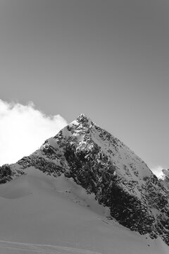 Minimalist black and white of a cloud-topped peak