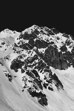 Jagged, snow-covered mountain peak in black and white