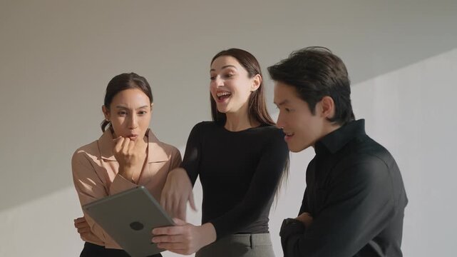 Team&rsquo;s Digital Delight: A close-knit group of colleagues are captivated by the content on a digital tablet. They showcase their teamwork and collaborative nature.