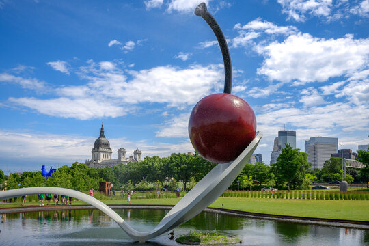 Minneapolis, Minnesota, July 13, 2019: Spoonbridge and Cherry sculpture in the Minneapolis Sculpture Garden with the Basilica of Saint Mary and the Minneapolis skyline in the background.