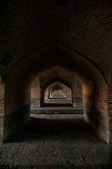 Fototapeta premium Beautiful view of historic arched corridors under the Si-o-se-pol (Allahverdi Khan Bridge) bridge in Isfahan, Iran.