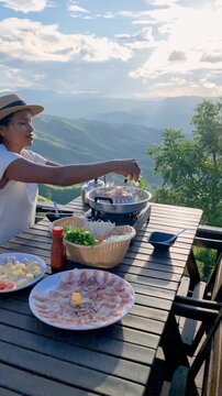 Savoring a delightful meal while soaking in breathtaking mountain views in Chiang Mai. The vibrant landscape enhances the joy of traditional cuisine in this serene spot in Thailand.
