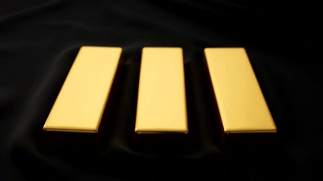 Three shiny gold bars arranged elegantly, symbolizing luxury and wealth in a dark background.