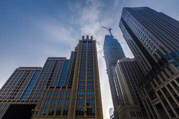 Obraz premium Tall Buildings Under the Sky with Construction Crane