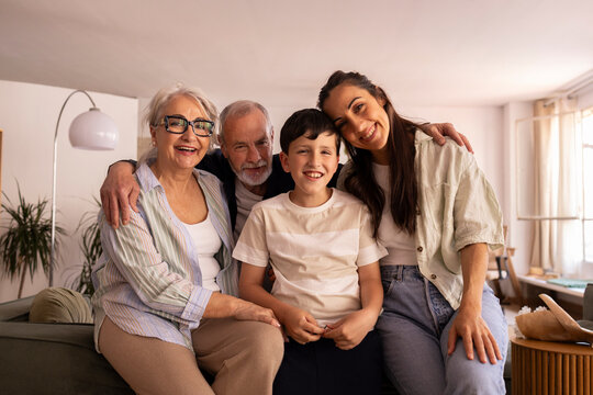 Happy multigenerational family portrait in living room showing love