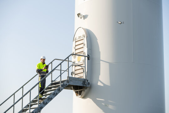 Engineer using drone for wind turbine inspection in renewable energy industry