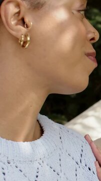 Vertical video: Talking woman in hoops smiling as friend placing hand on shoulder on patio helping