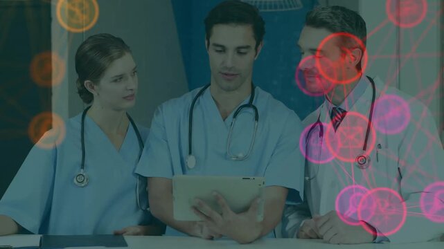 Three medics reviewing tablet at nurse desk, tablet tap starting pulsing icons beside team for care