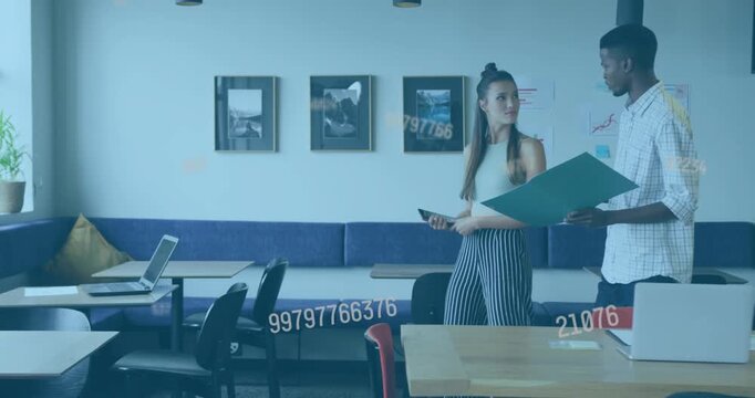 Man opening teal folder, woman checking phone, walking through business lounge, pausing, reviewing