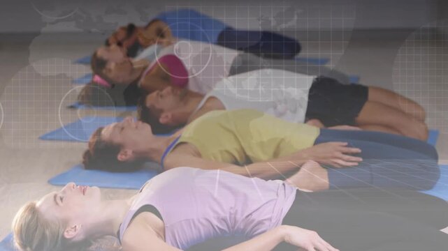 Group participants lying on mats holding supine rest while world-map grid HUD fading in for fitness