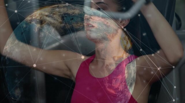 Woman reaching for pec handles and pressing, globe overlay showing metrics tracking fitness