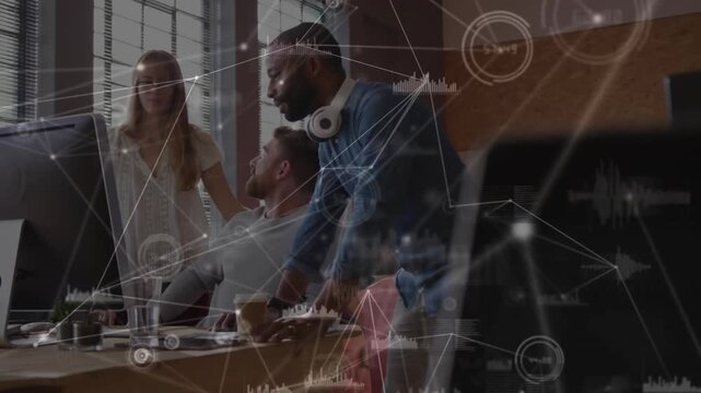 Business team leaning around screen, standing man pointing, colleagues gesturing and agreeing plan