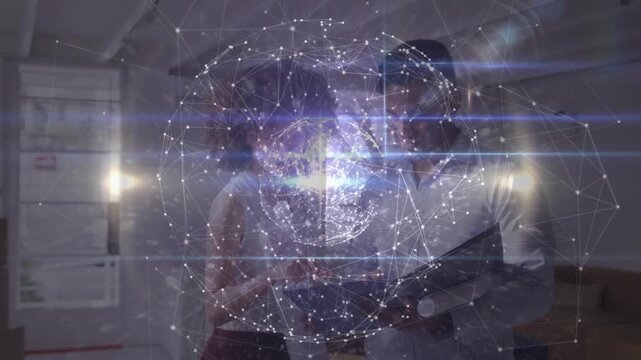 Team reviewing tablet and design plans, hologram globe overlaying and pulsing as woman pointing