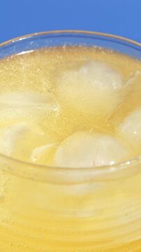 Glass with healthy flavored fresh sparkling kombucha, close-up of gas bubbles.  Iced fizzy drinks, and summer vibes.