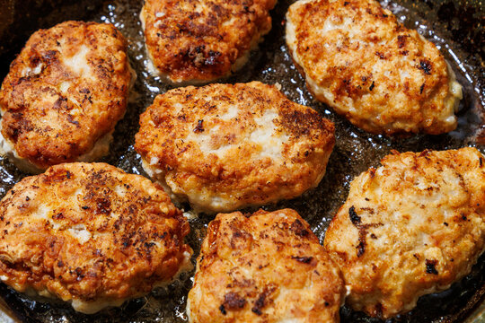 Minced meat cutlets are fried in oil in a frying pan