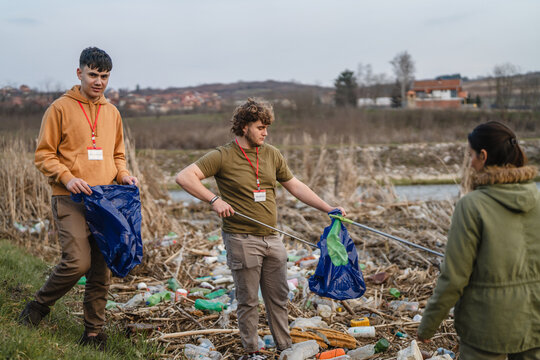 Volunteers cleaning plastic pollution from riverbank environment
