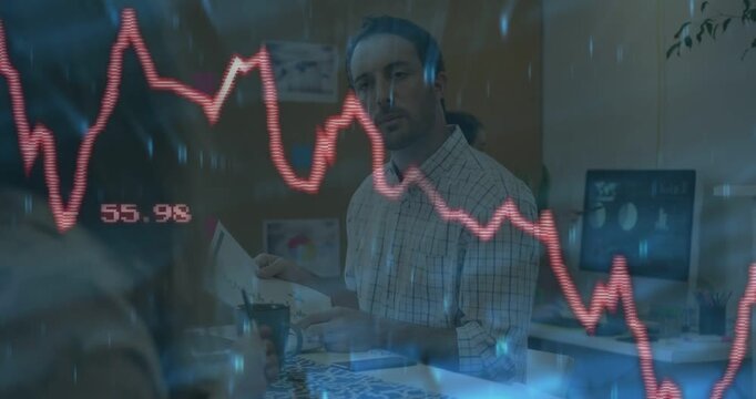 Vertical video: Seated man reviewing finances and reacting as red chart overlay updating values