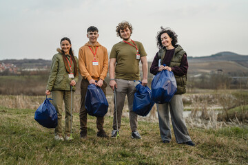 Young volunteers collecting garbage in nature for environmental protection