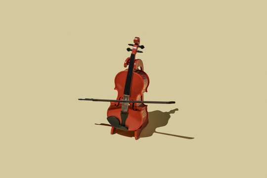 Wooden cello with bow on warm beige background in studio still life