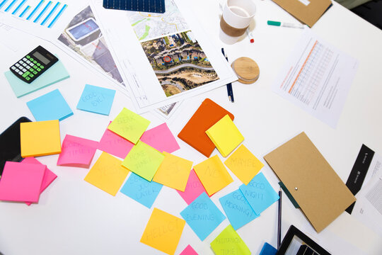 Colorful sticky notes and documents on meeting table in office workspace
