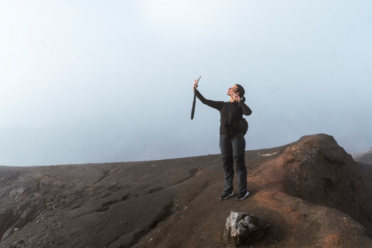 Person taking selfie while trekking in misty mountains on Java