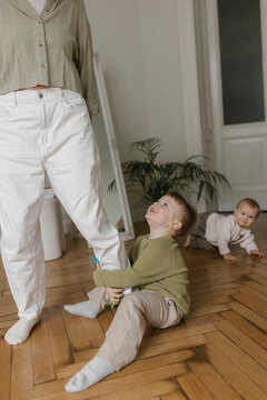 Mother with two children playing together at home in joyful moment
