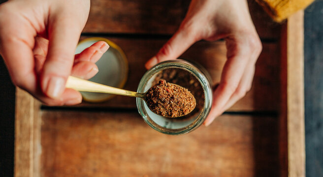 Hand holding spoon with propolis over jar indoors eco-friendly remedy