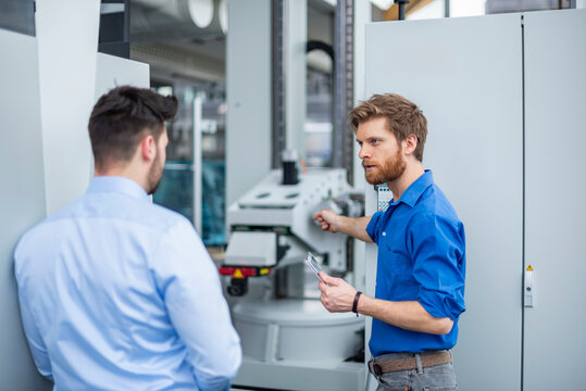 Engineer explaining industrial machine operation during business meeting