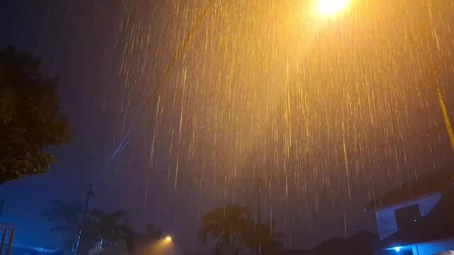 Heavy rain with flashes of lightning at night.