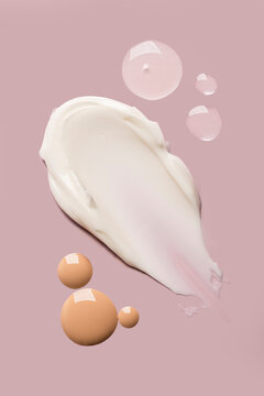 Cream and serum swatch with foundation on pink background beauty skincare