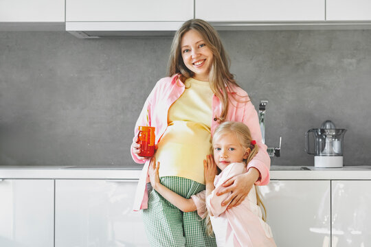 Pregnant mother and daughter sharing quality time in modern kitchen