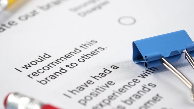 Customer satisfaction survey form with brand recommendation question and pencils on desk