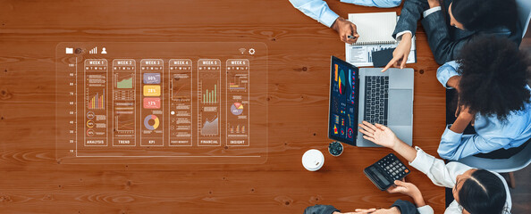 A team collaborates over data analytics in a modern office, using a laptop and documents to...