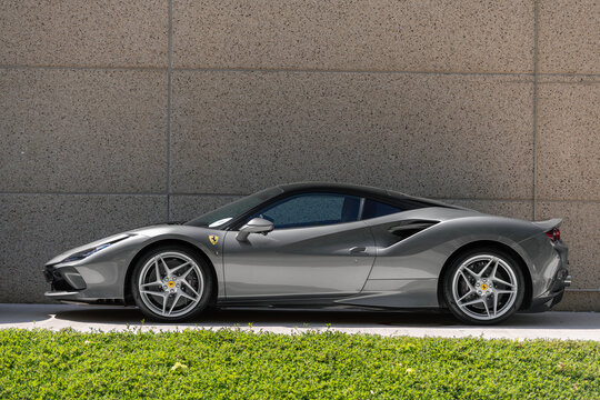 Windhof, Luxembourg - June 19th 2025 : View on a grey Ferrari F8 Tributo parked on a street along a wall.