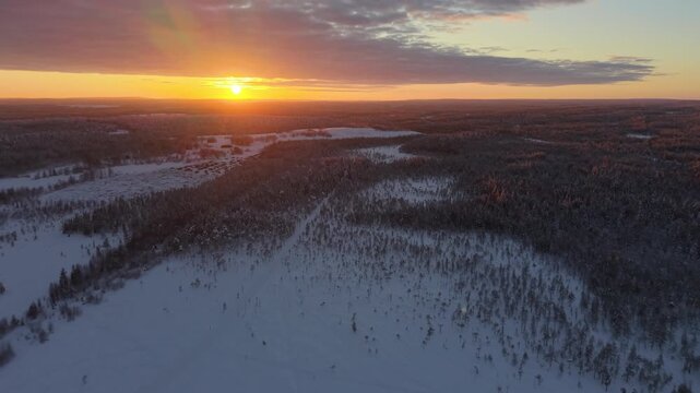 Aerial Dolly In Towards Sunset Over Snowy Arctic Forested Landscape