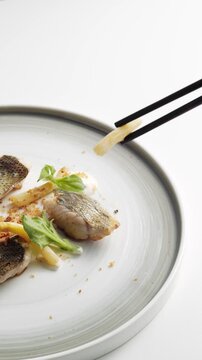 Close-up of Oriental Food Being Picked Up with Chopsticks