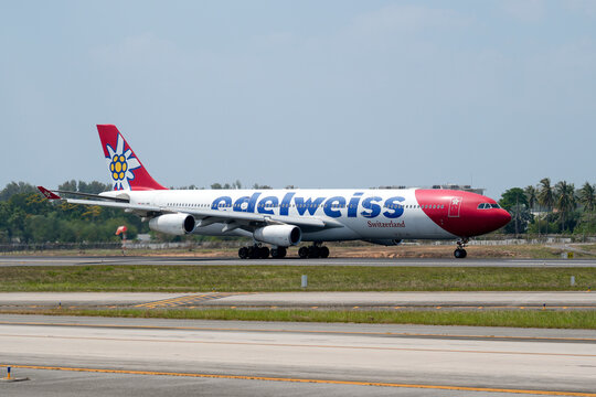 Edelweiss Switzerland airways airbus a340 take off above beautiful beach with people on the beach and sea, travel. Thailand, Phuket International airport. 09 March 2026.