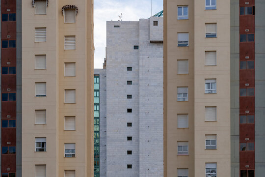 Urban architecture presents Benidorm Spain apartment facade with windows pattern vertical color accents shaping dense coastal residential city blocks