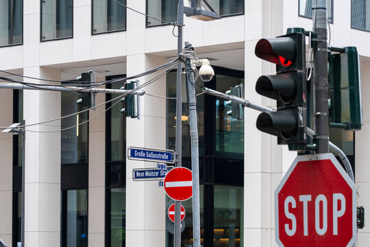 Stop sign and traffic light at urban street intersection with clear signage on modern facade expressing regulation and road safety control