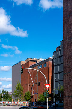 Urban street intersection with traffic light and yield signage beside modern architecture promoting mobility and traffic safety for city driving scenes